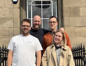 This is an image of four people standing together