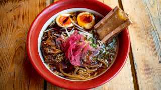 This is a photo of the Bone Daddies and Black Bear collaboration, which includes Bone Daddies beef bone broth, Black Bear beer braised brisket, bone marrow, pink pickled onions, bamboo shoots, beansprouts and a soy Clarence Court egg.
