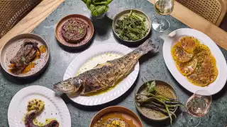 This is an image of dishes at The Counter Soho, including tomatoes, octopus and a whole fish