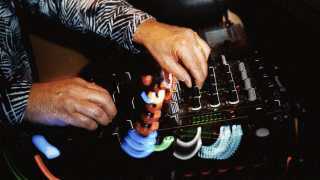 A photo of a DJ adjusting the decks