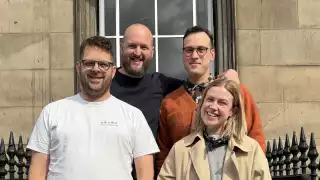 This is an image of four people standing together
